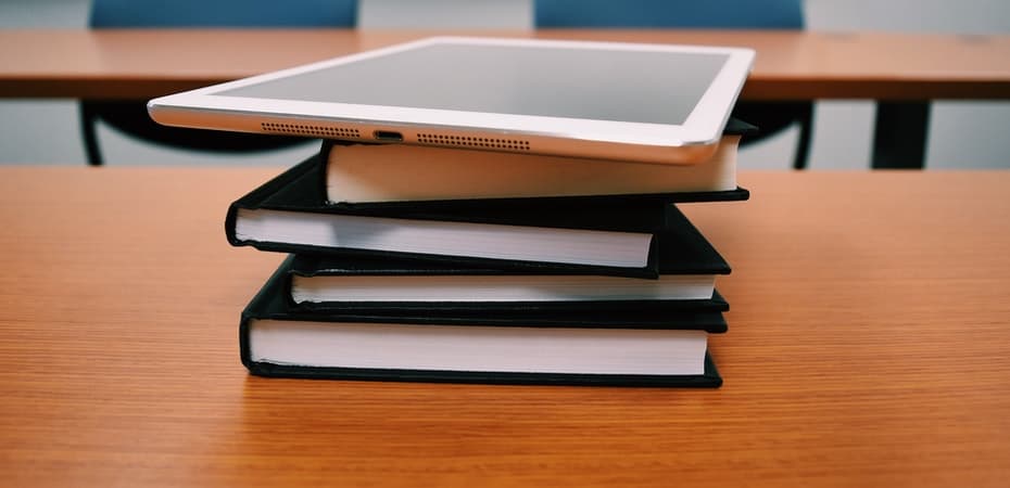 an iPad on a stack of books