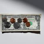 Coins on top of a dollar. What Are Income Share Agreements?