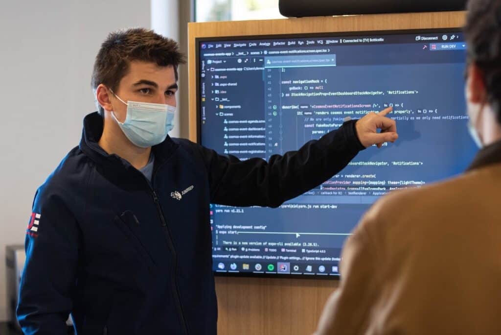 an instructor in a surgical mask teaching an Introduction to Programming class which programming language should i learn first?