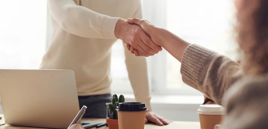 Two people shaking hands in an office. Top Tips to Ace Your Job Application for Cisco
