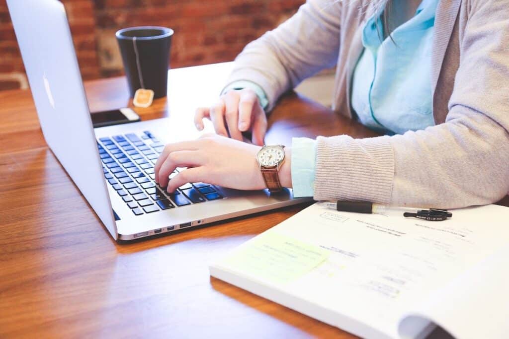 A student typing on a laptop on a table. How to Learn Ethical Hacking