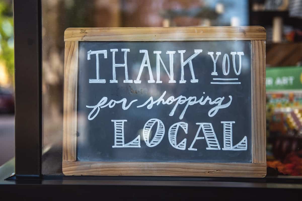 A shallow focus photo of “thank you for shopping local” written on a chalkboard