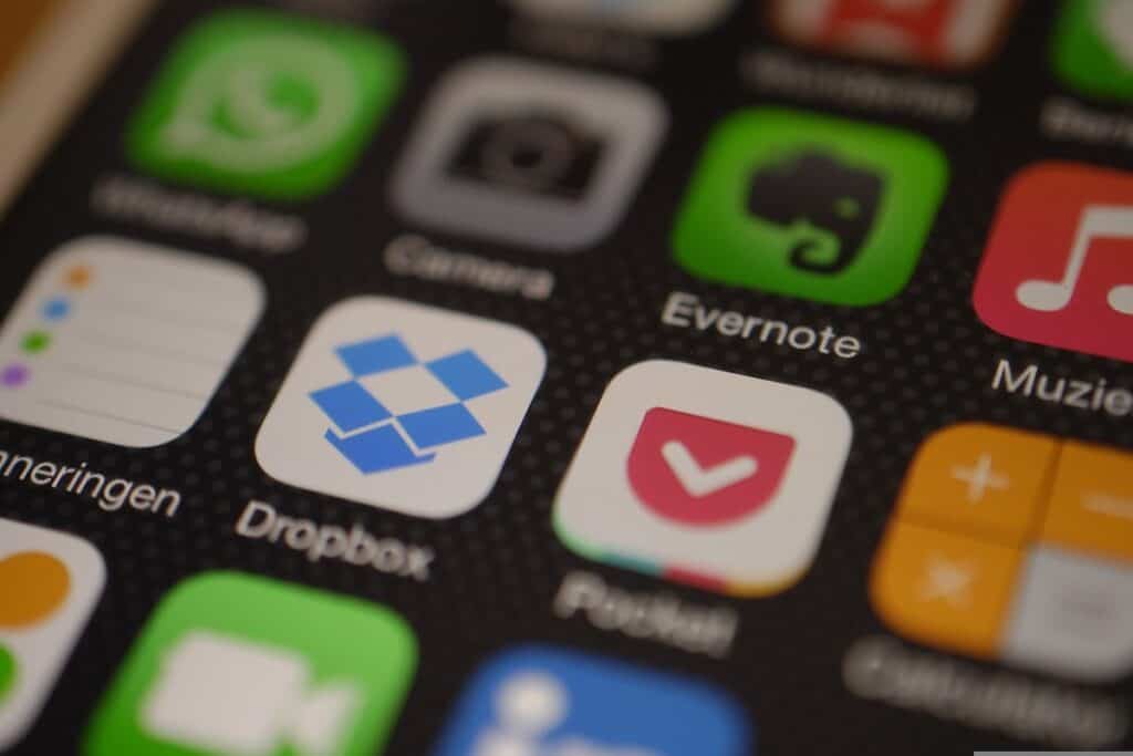 An iPhone home screen displays apps such as Dropbox and Evernote.