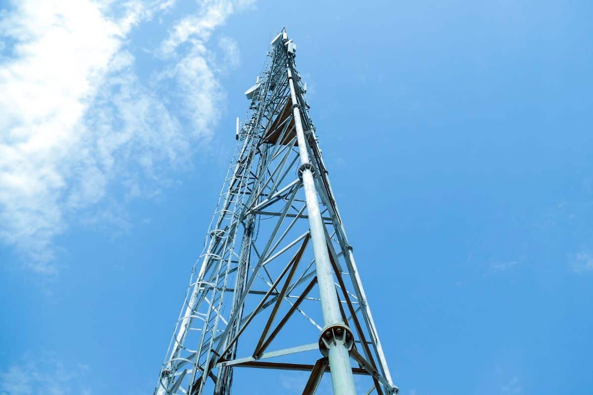 a cell tower and a blue sky with clouds