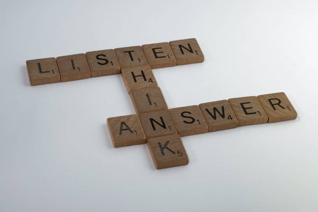 Wooden Scrabble tiles with letters that spell out the words listen, think, answer.