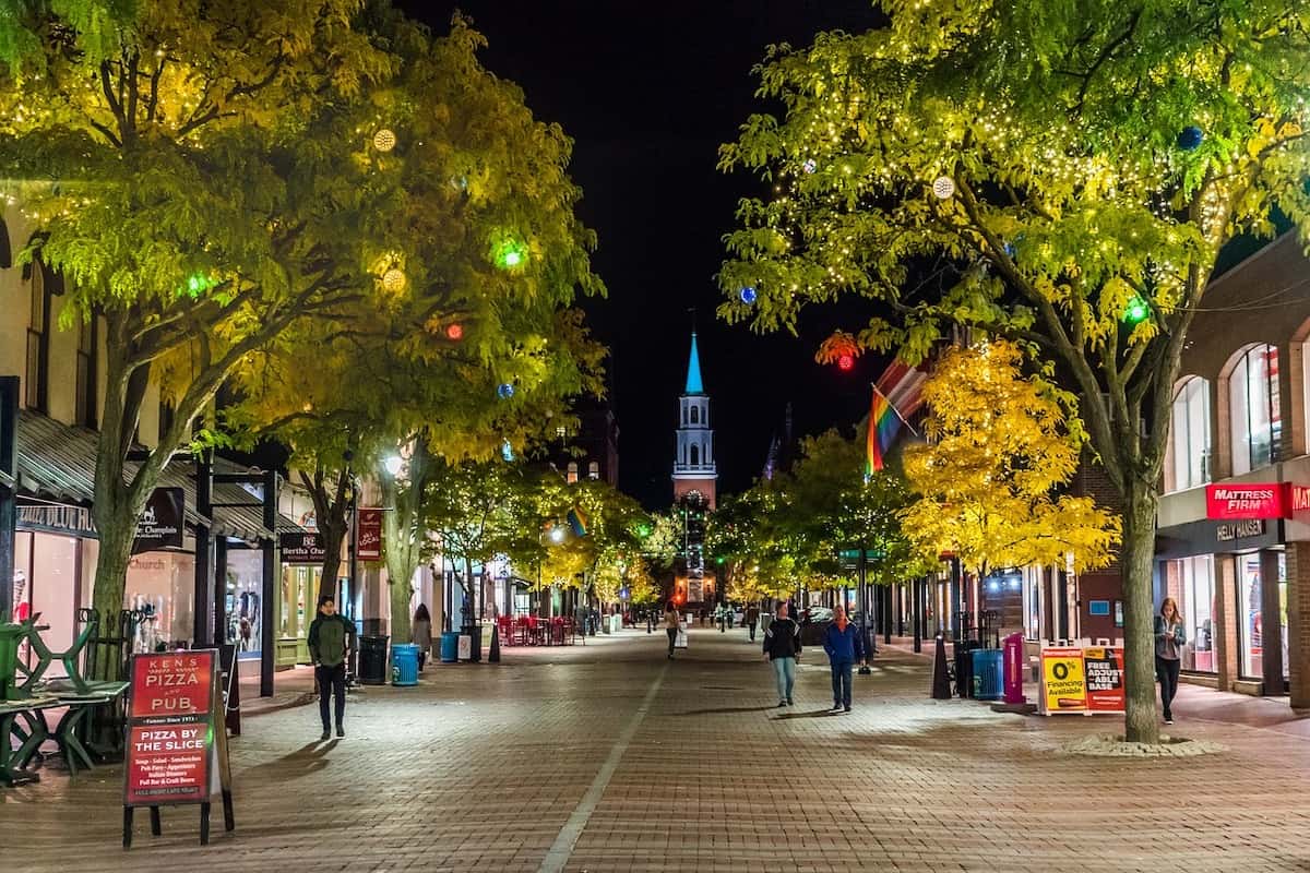 A view looking down a tree-lined street with shops in Burlington, Vermont.
